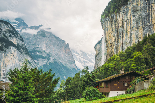 The town Lauterbrunnen in Switzerland with one of its Waterfalls in a summer landscape