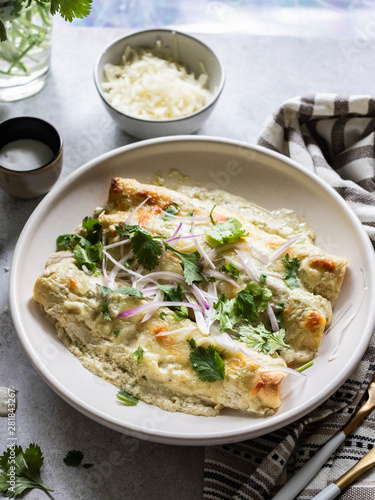 Cheesy enchiladas filled with chredded chicken and black beans, served with  creamy sauce photo