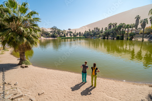 Girls watching Huacachina oasis lagoon, Ica, Peru, South America
