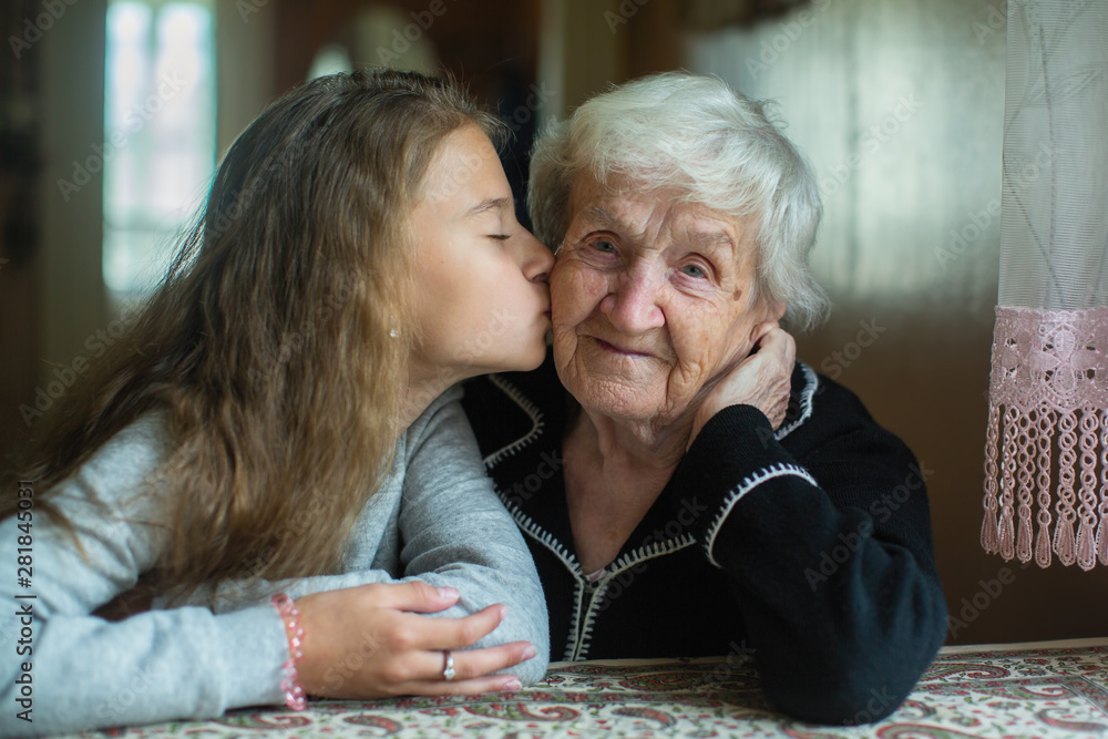 An elderly grandmother with her little granddaughter. - obrazy, fototapety, plakaty 