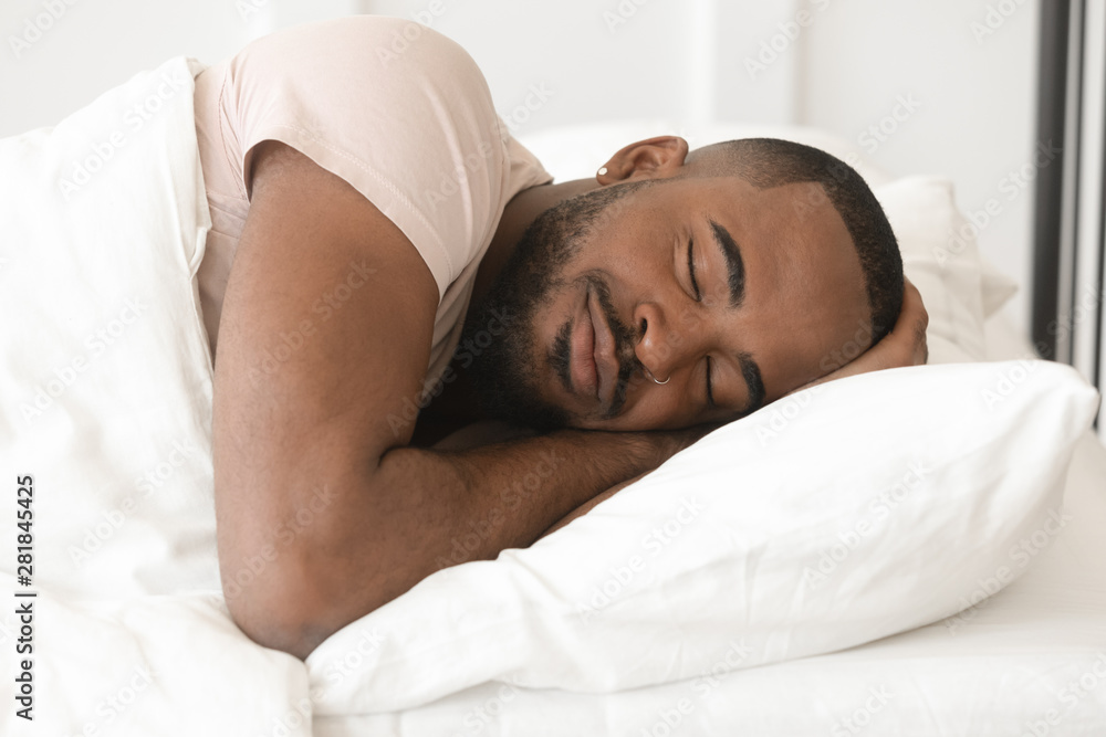 Serene calm young black man sleeping well alone in bed Serene calm young black man sleeping well alone in bed