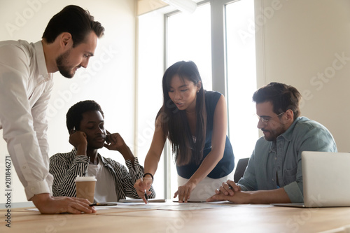 Serious multiethnic business team brainstorm on paperwork at group meeting