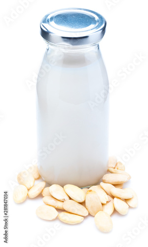 Almond milk in glass bottle. Includes peeled almonds. Isolated white background.