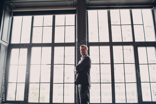 Portrait of a businessman at big window. Business and success concept.