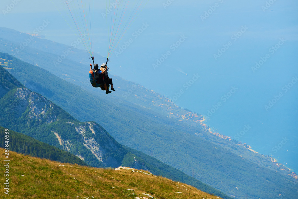 Paraglider flying over the Garda Lake Panorama of the gorgeous Garda lake surrounded by mountains. Paragliding is very popular sport in Monte Baldo. Paraglider flying over the Garda Lake Panorama of the gorgeous Garda lake surrounded by mountains. Paragliding is very popular sport in Monte Baldo.