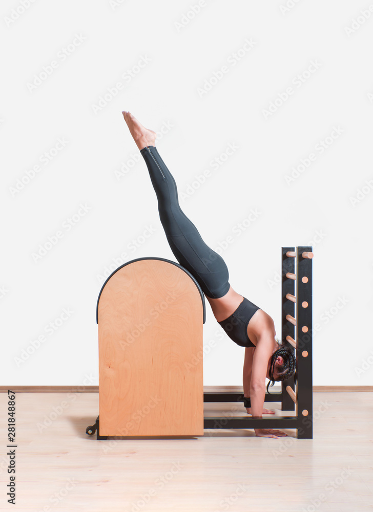 Young Girl doing exercises on ladder barrel - Pilates Stock Photo