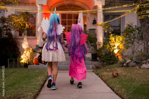 On Halloween, sisters are going trick or treating with their pet pug.