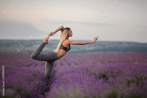Sporty woman practicing yoga. Woman on the lavender field. Healthy lifestyle concept.