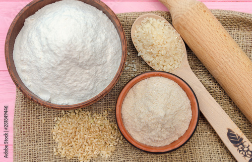 Whole grain rice flour in bowls. The whole grain of rice. Unpolished brown rice in wooden spoon. Healthy food background.