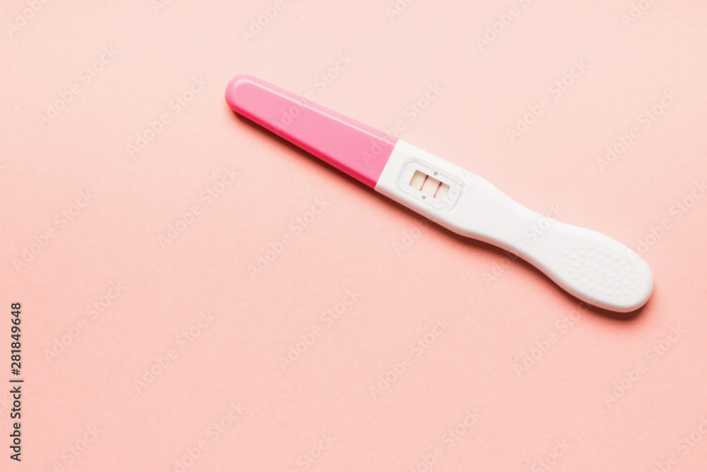 Positive pink plastic pregnancy test on pink background. Positive pink plastic pregnancy test on pink background.