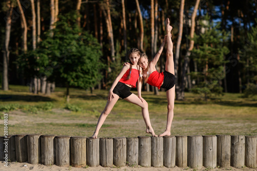 Sisters do gymnastics on the sand
