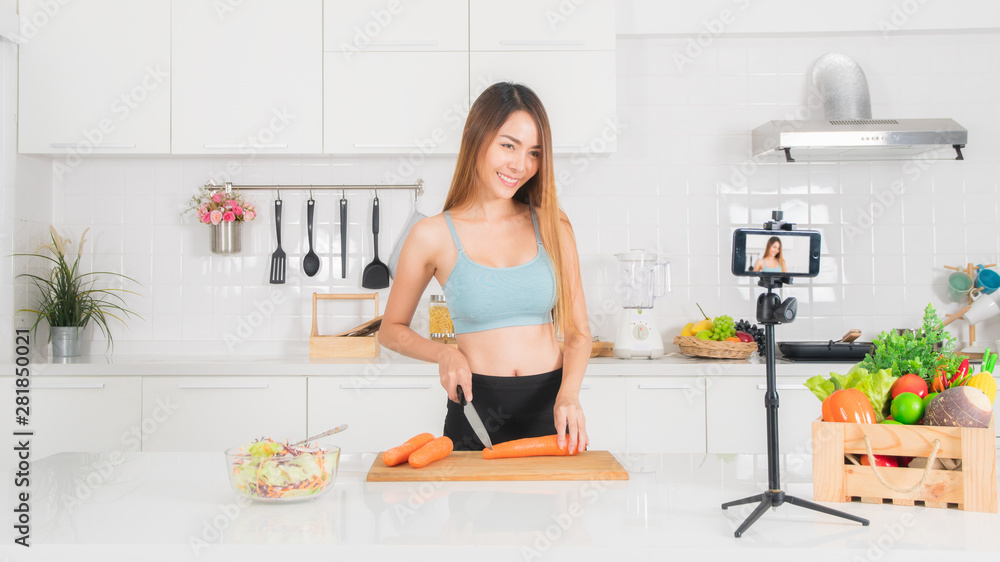 Woman is recording the cooking video in the kitchen.