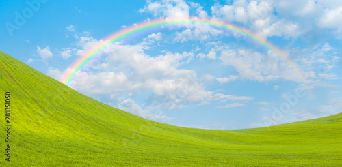 Beautiful landscape with green grass field and sun rays in the background amazing rainbow