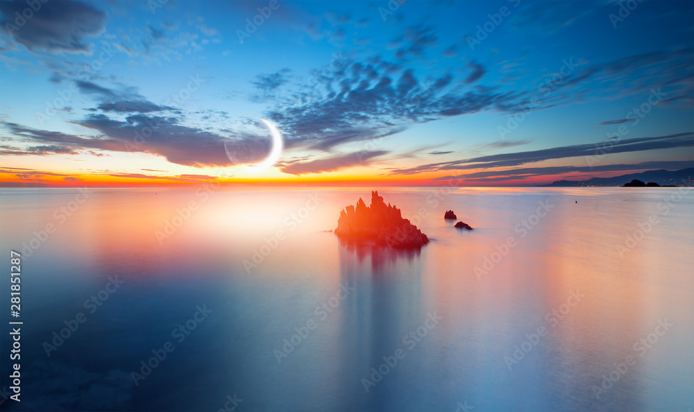 Fototapeta premium Long exposure of sunset at Alanya Beach, Alanya, Antalya - Long exposure image of Dramatic sky and seascape with rock and crescent moon