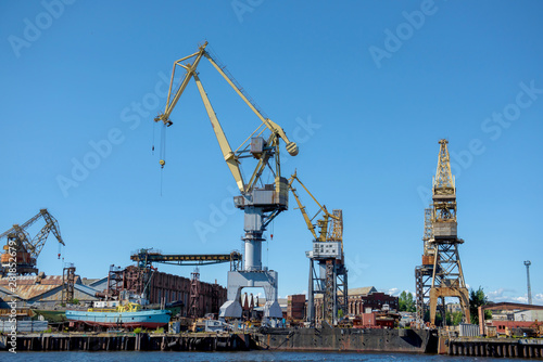 Loading cranes at the sea port. Cargo transportation by ships.