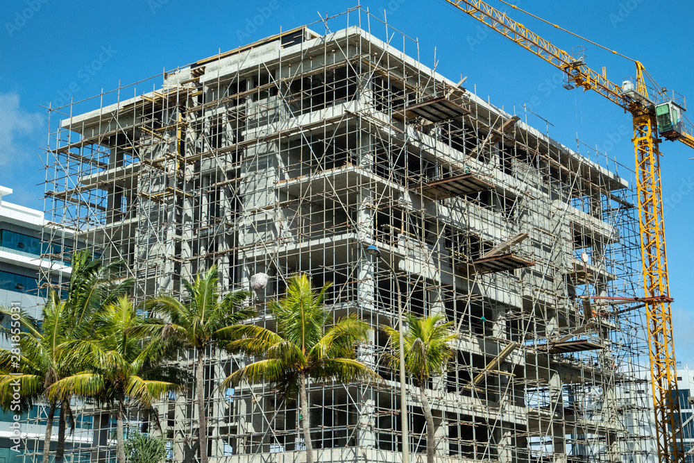 High building under construction with scaffolding and building crane in Port Louis and on Mauritius island, africa High building under construction with scaffolding and building crane in Port Louis and on Mauritius island, africa