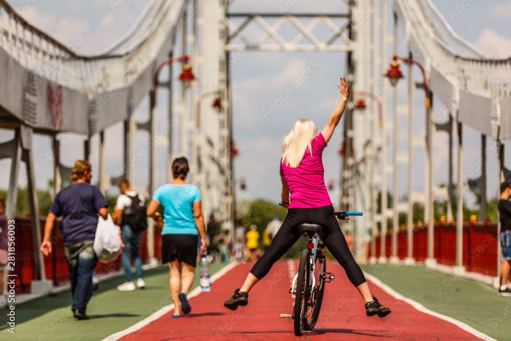 Obraz premium Woman riding bicycle with her legs in the air