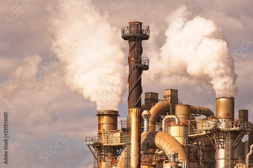 Industrial plant with smoking smokestack,tubes,silos.