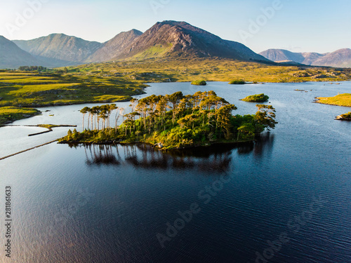 Twelve Pines Island, standing on a gorgeous background formed by the sharp peaks of a mountain range called Twelve Pins or Twelve Bens, Connemara, County Galway, Ireland photo