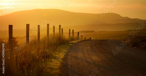 Sunset in Connemara. Scenic Irish countryside road leading towards magnificent mountains, County Galway, Ireland.