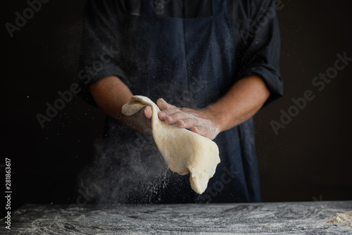 Obraz na plátně male chef hands toss pizza cake, cooking concept