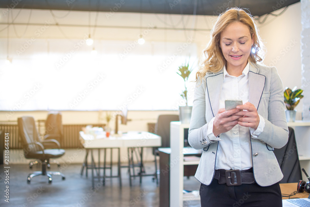 Middle age business woman using phone in office. Copy space available. Middle age business woman using phone in office. Copy space available.