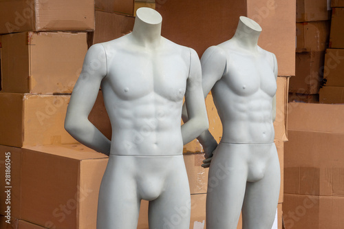 Mannequins of men on the background of cardboard boxes with clothes. photo