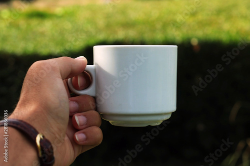 Person picking up a cup of coffee.