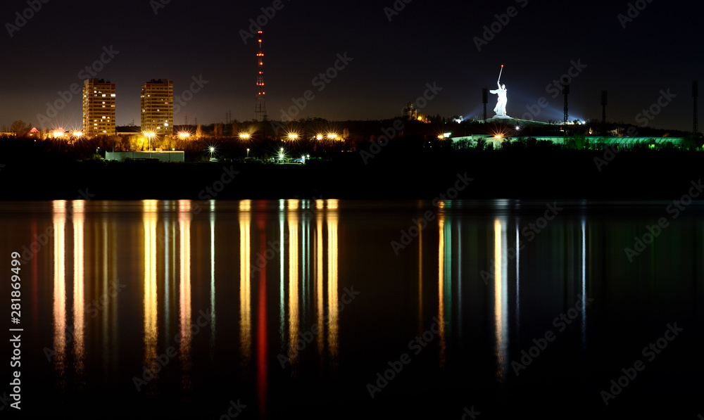 Reflection of a night city in a calm river.