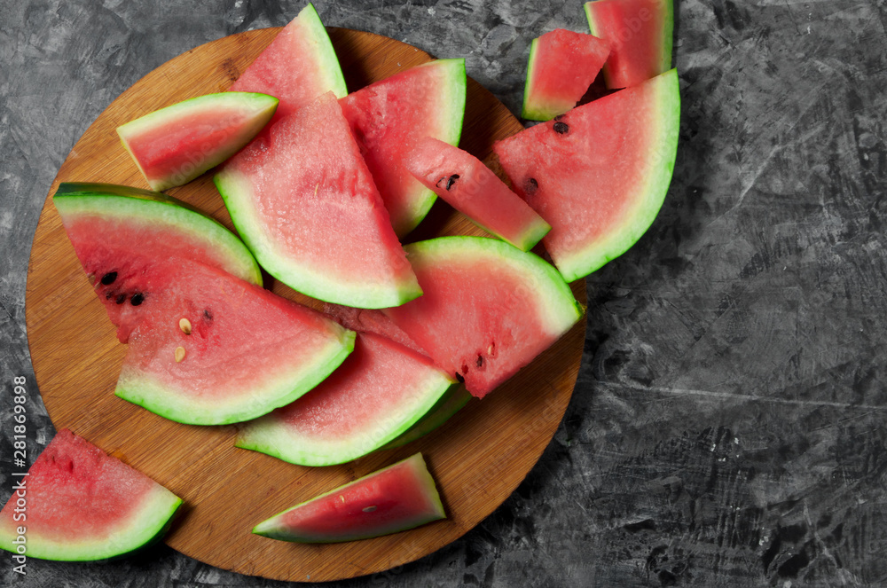Pieces of watermelon. Sliced juicy watermelon on a gray concrete surface. View from above. Copy space. Pieces of watermelon. Sliced juicy watermelon on a gray concrete surface. View from above. Copy space.