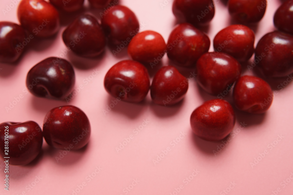 Red sweet cherry scattered on a pink background Red sweet cherry scattered on a pink background