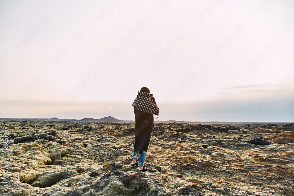 Young girl takes pictures of icelandic landscapes