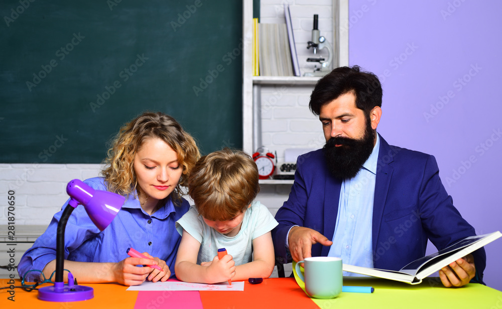 Schoolboy drawing with his parents. Mom helping her little child with homework. Happy family. Mother father and son drawing together. Mum and son together painting. First time to school. School kid. Schoolboy drawing with his parents. Mom helping her little child with homework. Happy family. Mother father and son drawing together. Mum and son together painting. First time to school. School kid.