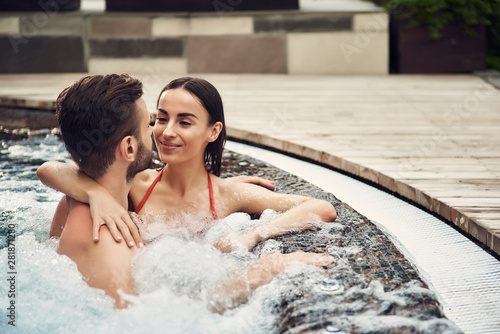 Couple in swimming pool looking to each other