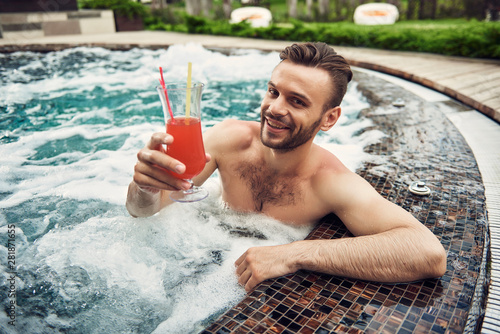 Handsome bearded man having rest in the swimming pool