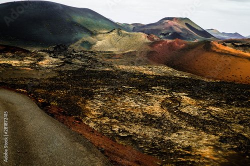 incredibly beautiful volcanoc landscape with black sand and red mountains and a beautiful sky during the day on the spanish island of Canary Lanzarote photo