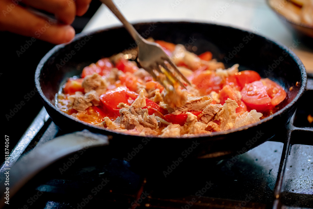bachelor man cooking snake with boiled meat and tomatoes at pan. domestic bachelors meals eating. bachelor man cooking snake with boiled meat and tomatoes at pan. domestic bachelors meals eating.