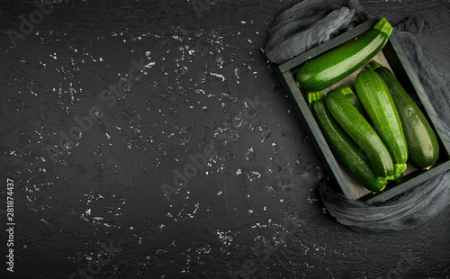 Fresh green zucchini on a dark table. The view from the top. Copy space.