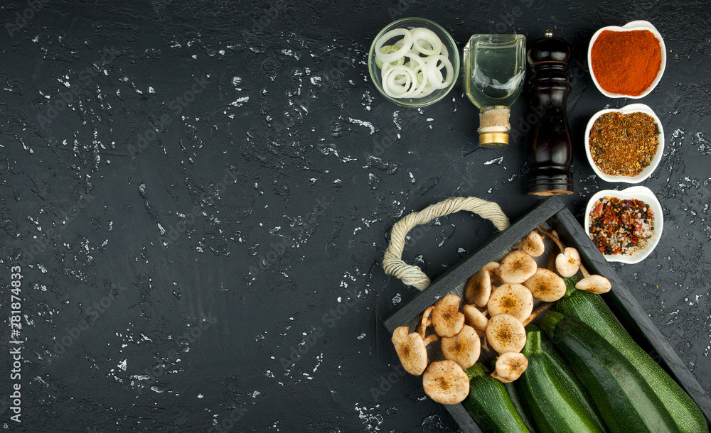 Fresh zucchini, mushrooms, spices and herbs on a black board. View from above. Copy space Fresh zucchini, mushrooms, spices and herbs on a black board. View from above. Copy space