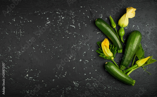 Fresh green zucchini on a dark table. The view from the top. Copy space.