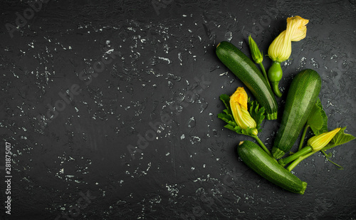 Fresh green zucchini on a dark table. The view from the top. Copy space.