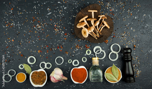 Fresh mushrooms with spices and herbs on black board. View from above. Copy space. © Виктория Саврей