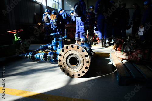 Shallow depth of field image with iron industrial equipment used in the oil and gas drilling industry laid on the ground of a workshop