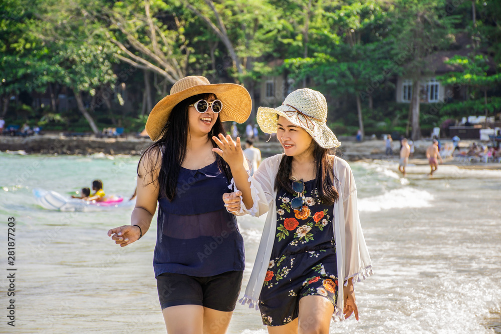 Young asian woman having fun at tropical beach on vacation, Couple of asian girl walk on the beach with bright sun light, Samed island, Thailand, Chubby girl enjoying on the sea, Lifestyle concept
