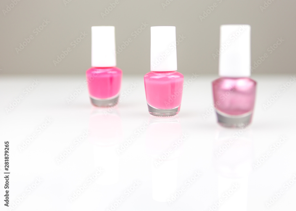 three bottles of bright pink nail polish in a row three bottles of bright pink nail polish in a row
