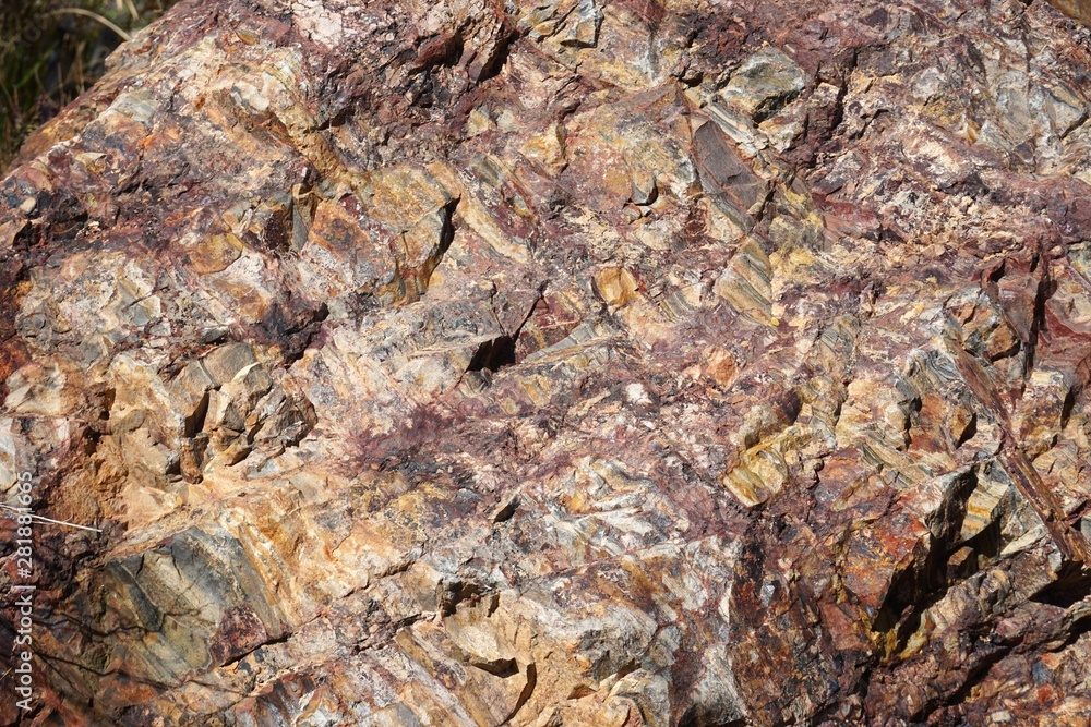 Macro detail of rough natural rock texture with variegated colors Macro detail of rough natural rock texture with variegated colors