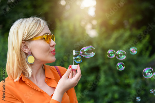 Blond girl blowing bubbles outdoor