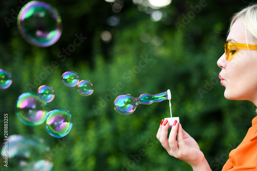 Blond girl blowing bubbles outdoor