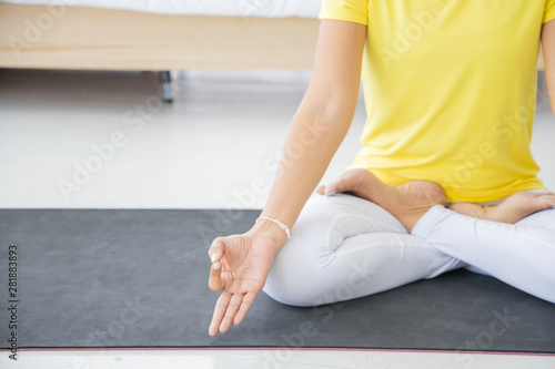 yellow shirt young woman concentrate doing yoga exercise in her bedroom