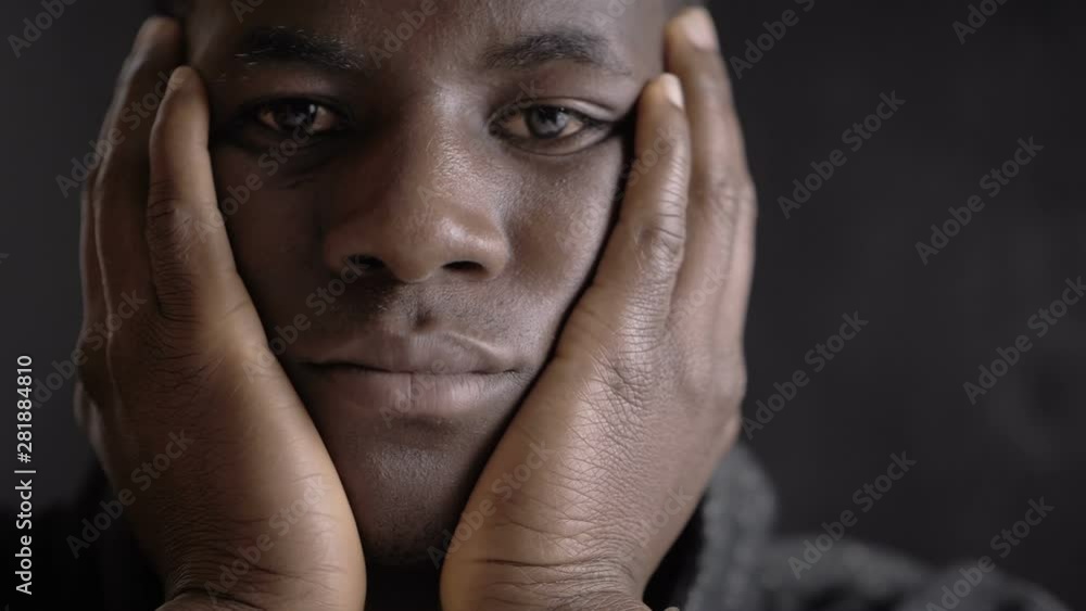 sad pensive bored young black african man looking at camera in the dark sad pensive bored young black african man looking at camera in the dark